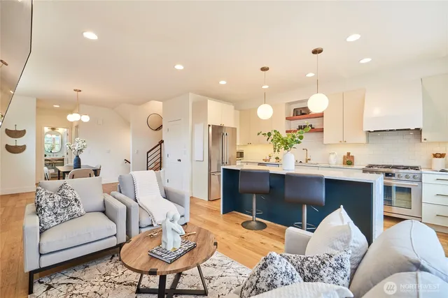 a living room with furniture kitchen view and a chandelier