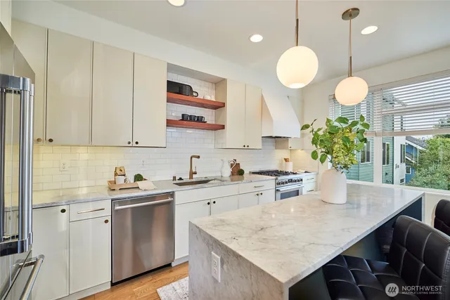 a kitchen with a sink a counter appliances and cabinets