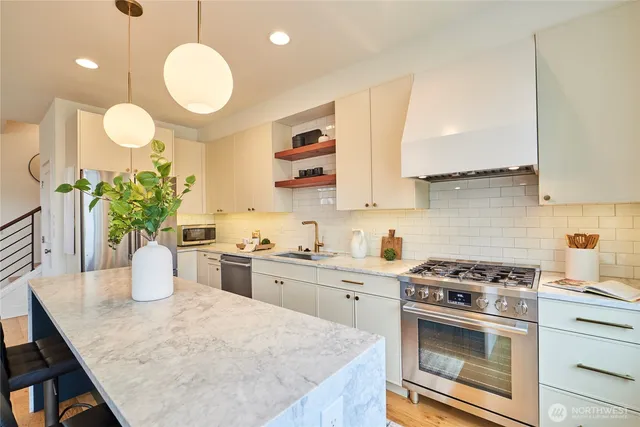 a kitchen with a stove a sink cabinetry and potted plant