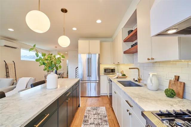 a kitchen with stainless steel appliances granite countertop a sink a stove and a refrigerator