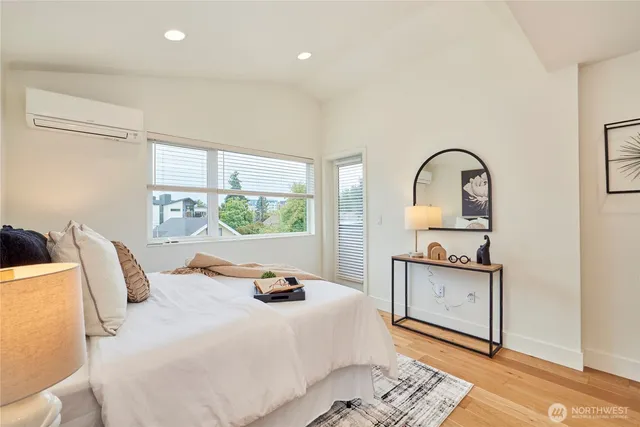 a bedroom with bed a mirror and window