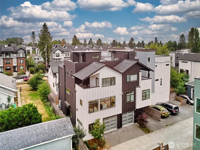 a view of a white house with a big yard and large tree
