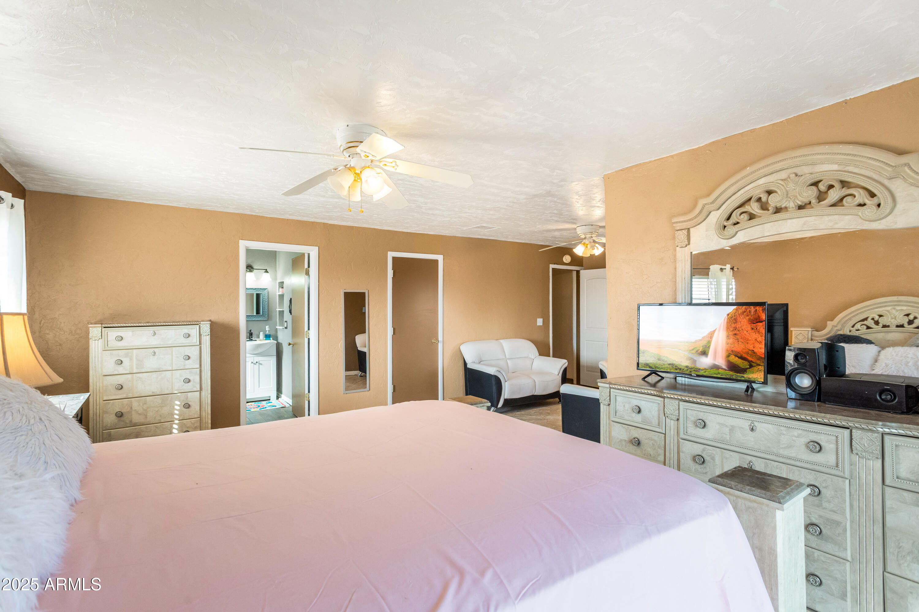 4181 West Double Adobe Road McNeal, AZ 85617 - Photo 21 of 41 a bedroom with a bed a chandelier and a flat tv screen on dresser