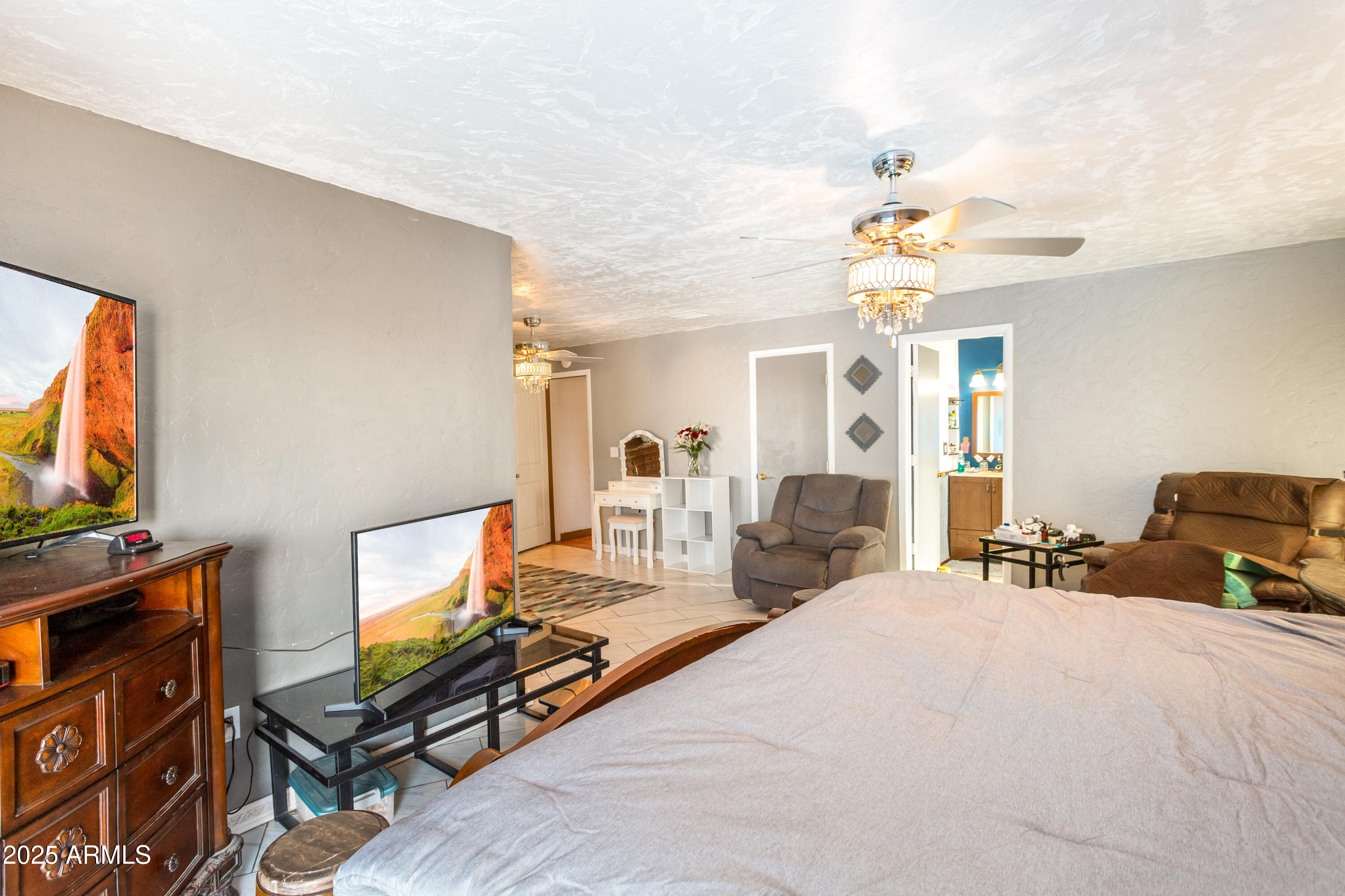 4181 West Double Adobe Road McNeal, AZ 85617 - Photo 24 of 41 a bedroom with furniture a flat screen tv and a chandelier