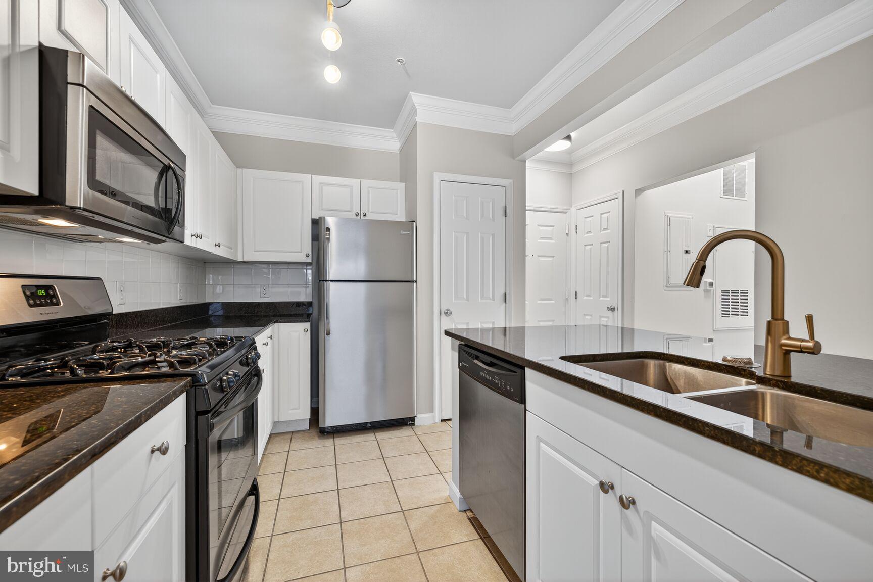 7 Granite Place, Unit 215 Gaithersburg, MD 20878 - Photo 15 of 36 a kitchen with a sink a stove and refrigerator