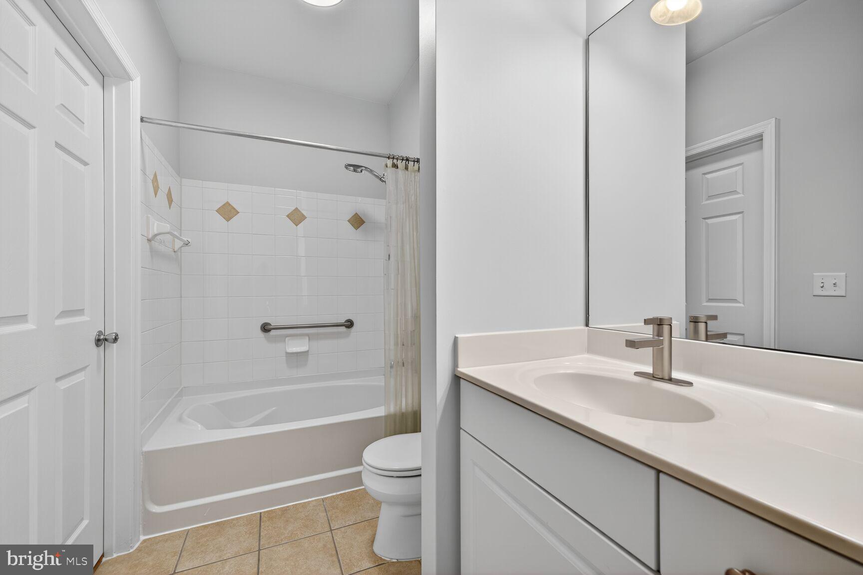 7 Granite Place, Unit 215 Gaithersburg, MD 20878 - Photo 23 of 36 a bathroom with a sink a toilet a mirror a bathtub and shower