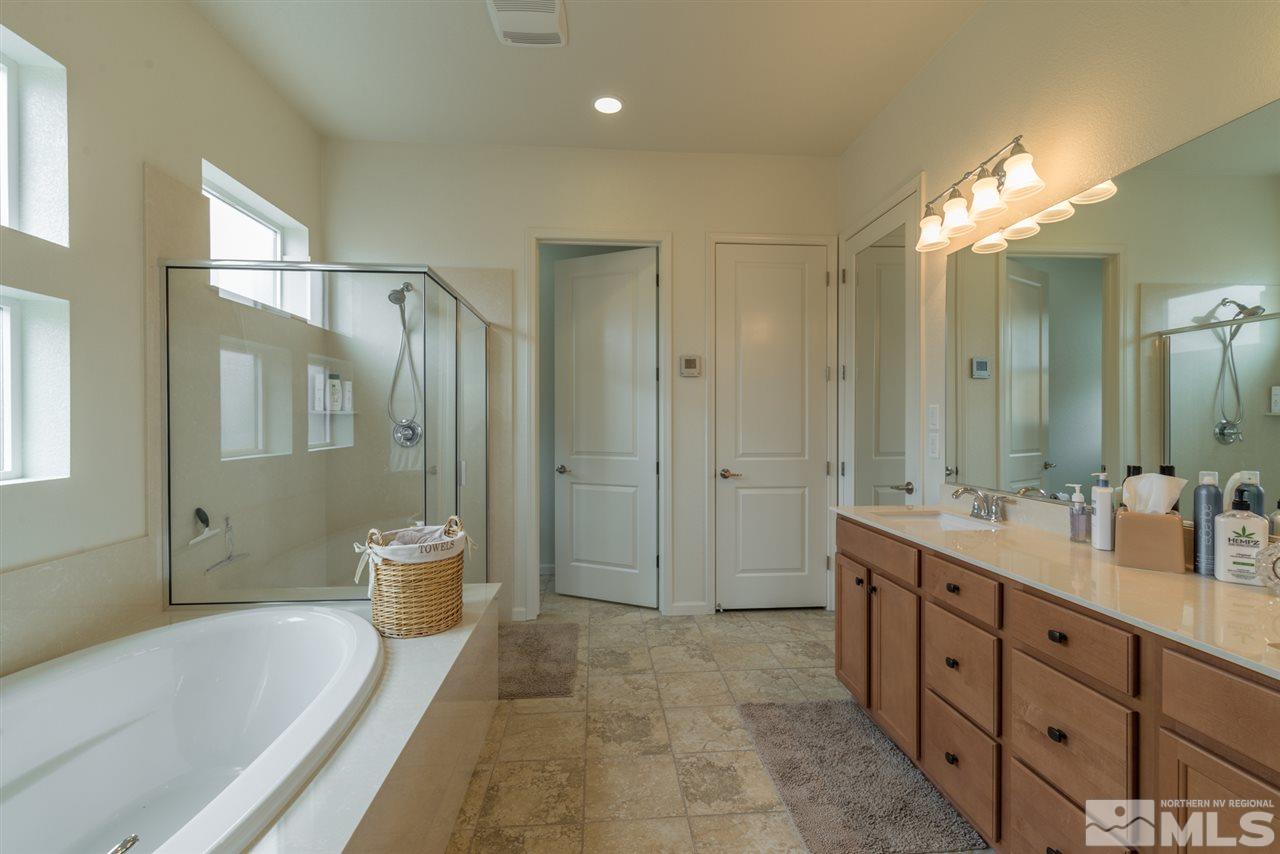 1255 Wakefield Trail Reno, NV 89523 - Photo 17 of 25 a spacious bathroom with a double vanity sink toilet mirror and bathtub
