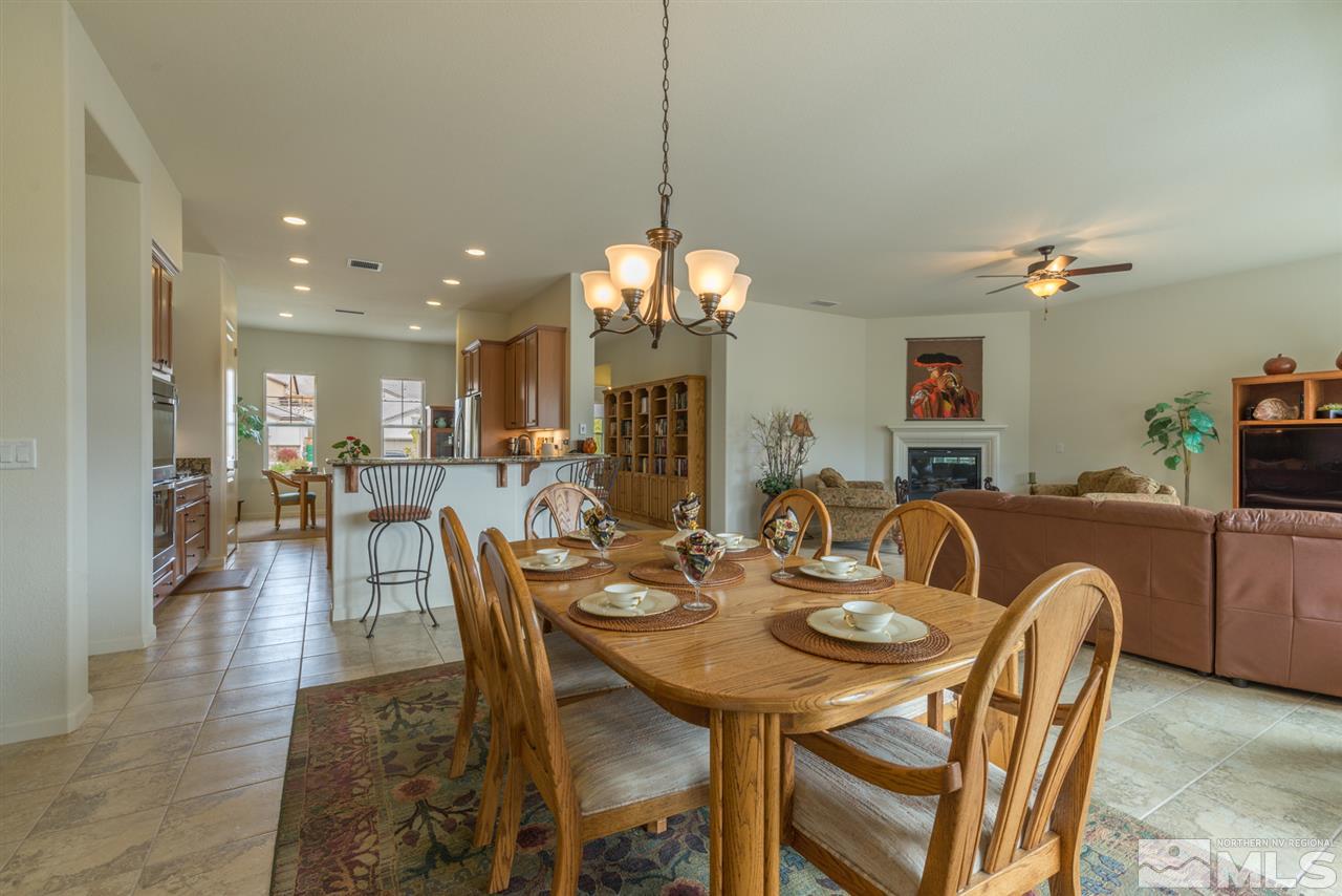 1255 Wakefield Trail Reno, NV 89523 - Photo 9 of 25 a dining room with wooden floor a chandelier a wooden table and chairs