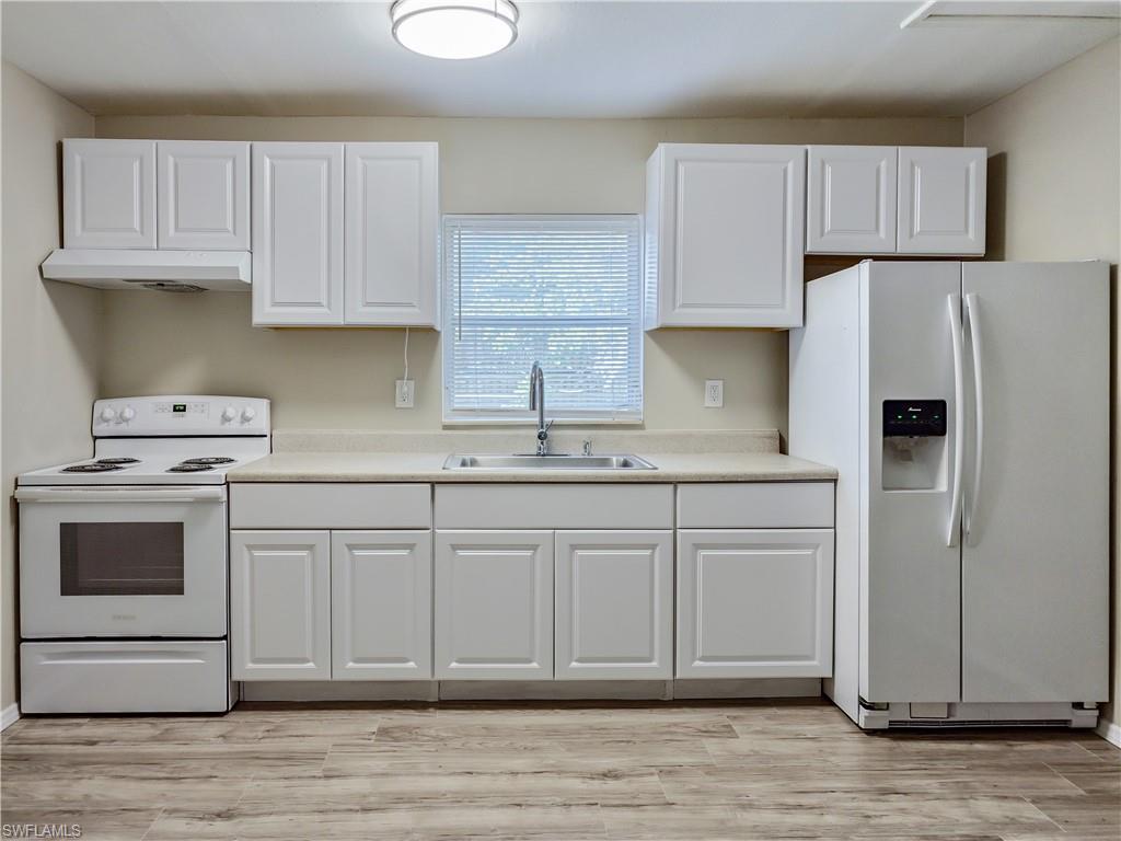 3488 Roberts Street Mims, FL 32754 - Photo 4 of 15 a kitchen with granite countertop white cabinets and refrigerator