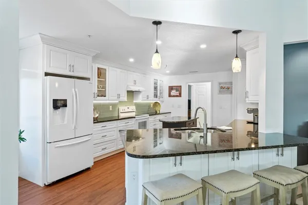 a kitchen with white cabinets and refrigerator