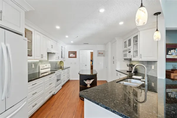 a kitchen with stainless steel appliances granite countertop a sink stove and refrigerator