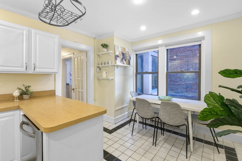 857 Beacon Street, Unit 34 Boston, MA 02215 - Photo 12 of 26 a kitchen with a table chairs refrigerator and cabinets