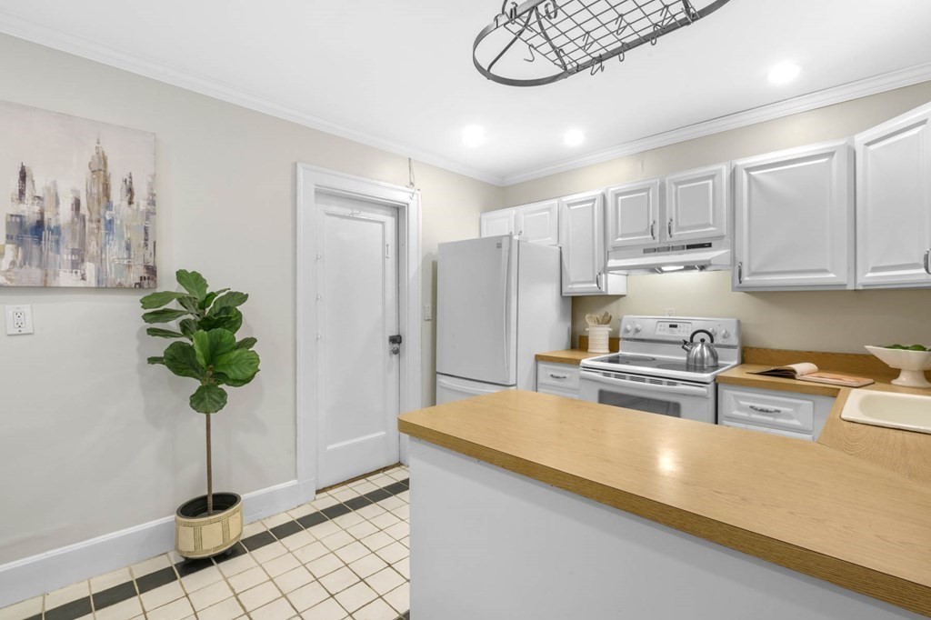 857 Beacon Street, Unit 34 Boston, MA 02215 - Photo 13 of 26 a kitchen with stainless steel appliances a white refrigerator a stove a microwave and cabinets