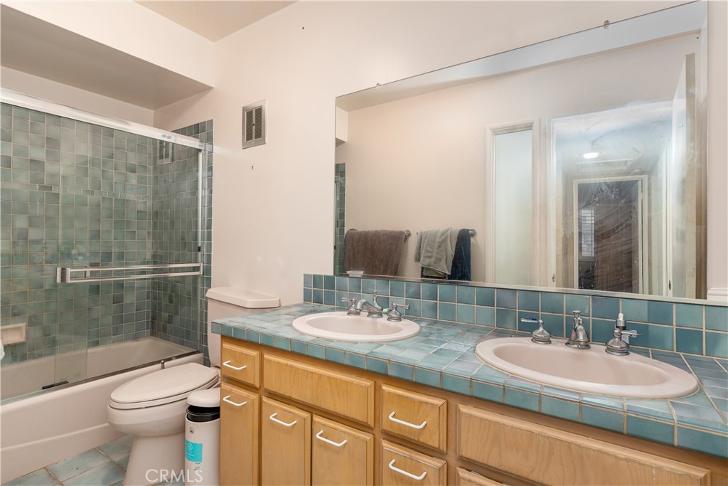 4967 Chapala Drive Riverside, CA 92507 - Photo 26 of 34 a bathroom with a double vanity sink toilet and shower