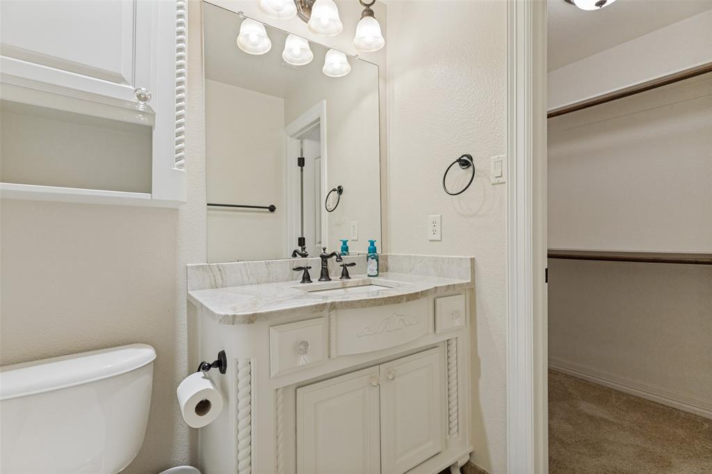 229 Arbor Lane Haslet, TX 76052 - Photo 16 of 34 Bathroom vanity with a light-toned countertop, a built-in sink, and dark-finished fixtures