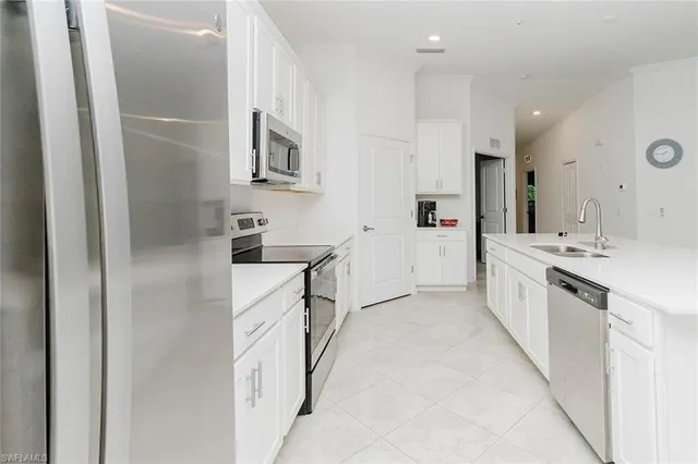 a large white kitchen with stainless steel appliances