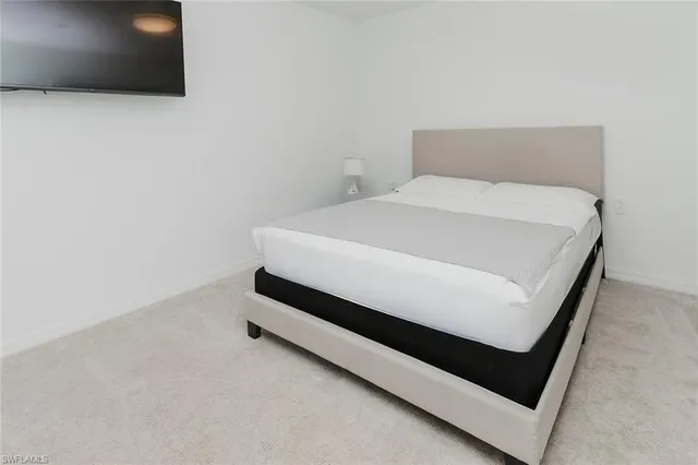 a bed sitting in a bedroom next to a lamp