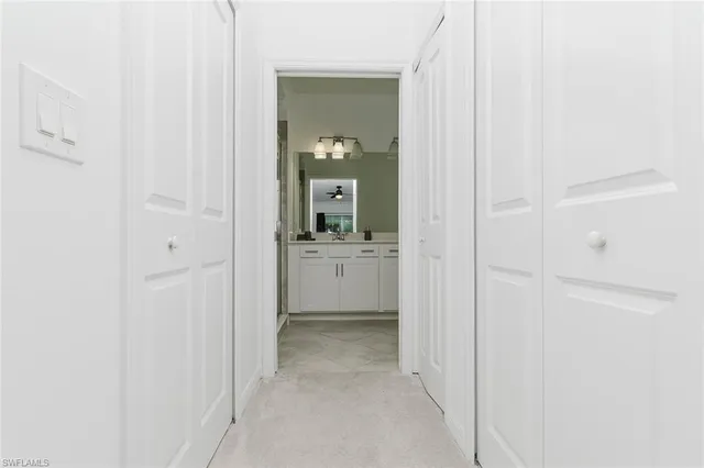 a view of a hallway with a white cabinet and a sink