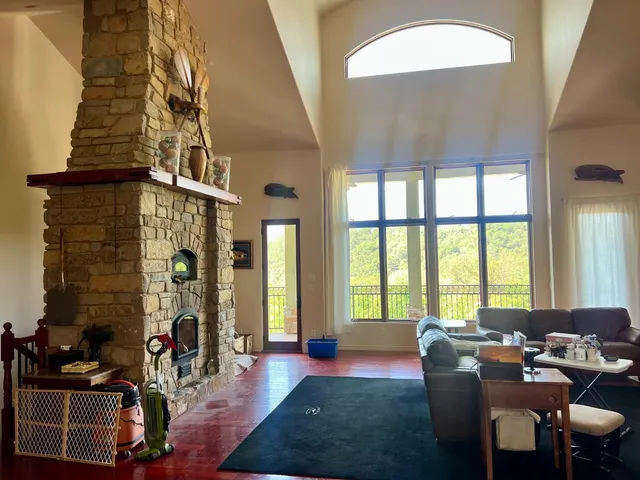 a living room with fireplace furniture and a floor to ceiling window