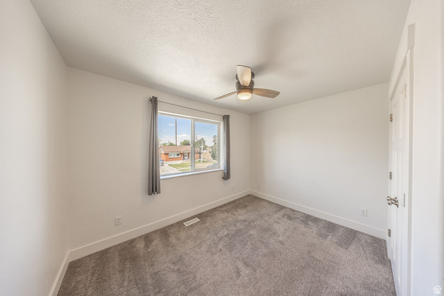 4991 South 475 West Washington Terrace, UT 84405 - Photo 25 of 31 Bedroom #2. Ceiling fan. Light colored carpeting. Closet doors on right. White walls.