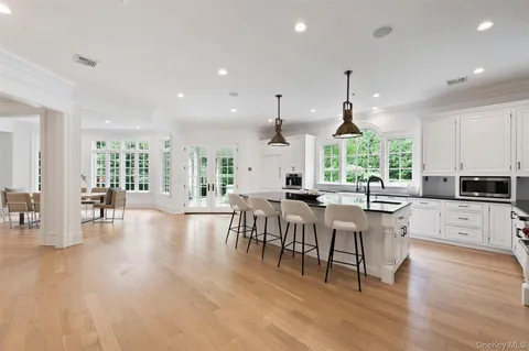 a kitchen with lots of counter and chairs