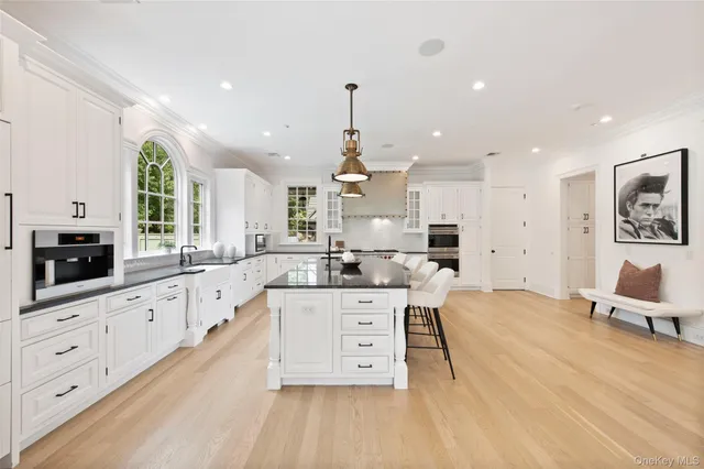 a large kitchen with kitchen island white cabinets and stainless steel appliances