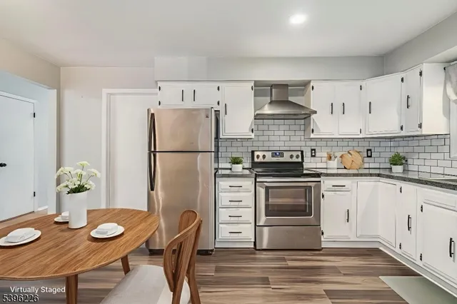 a kitchen with stainless steel appliances granite countertop a stove a refrigerator and a stove