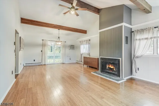 a view of empty room with fireplace and wooden floor
