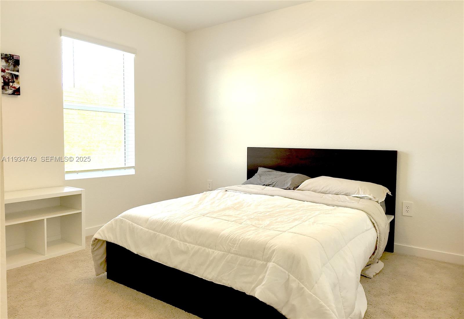 12913 Southwest 265th Terrace, Unit 1 Homestead, FL 33032 - Photo 14 of 22 a bedroom with a bed and a window