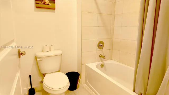 a white toilet sitting next to a bath tub