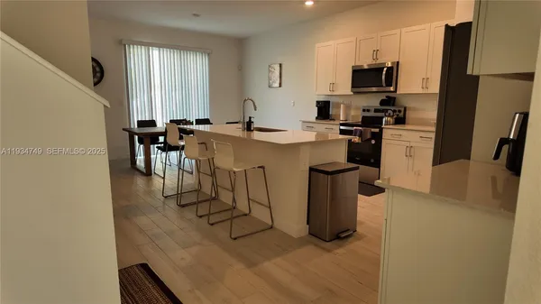 a kitchen with refrigerator and chairs