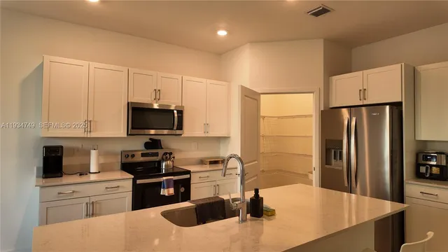 a kitchen with stainless steel appliances granite countertop a sink a stove and a refrigerator
