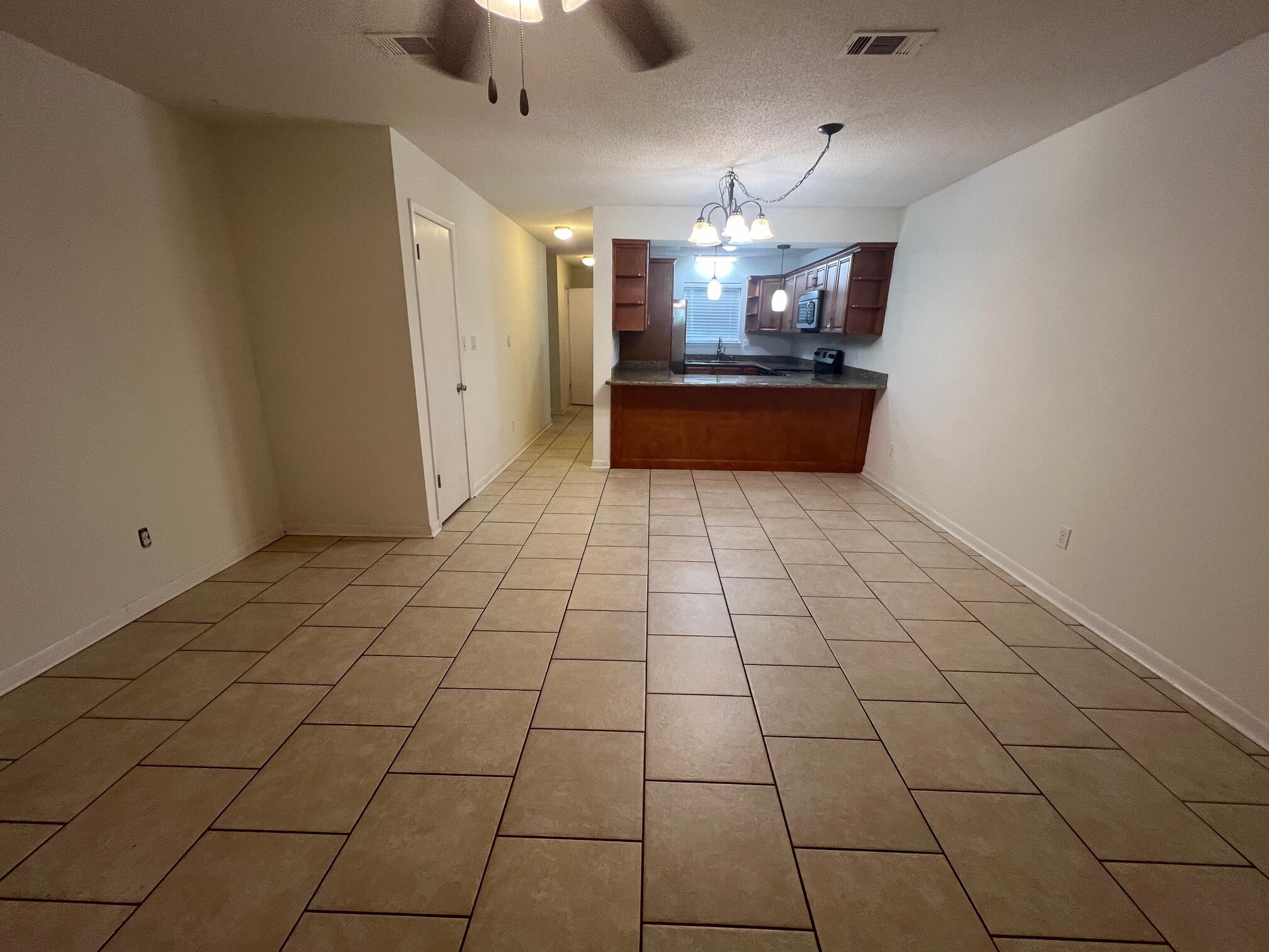 115 Hughes Street Northeast, Unit D4 Fort Walton Beach, FL 32548 - Photo 11 of 29 a large room with chandelier fan and kitchen view