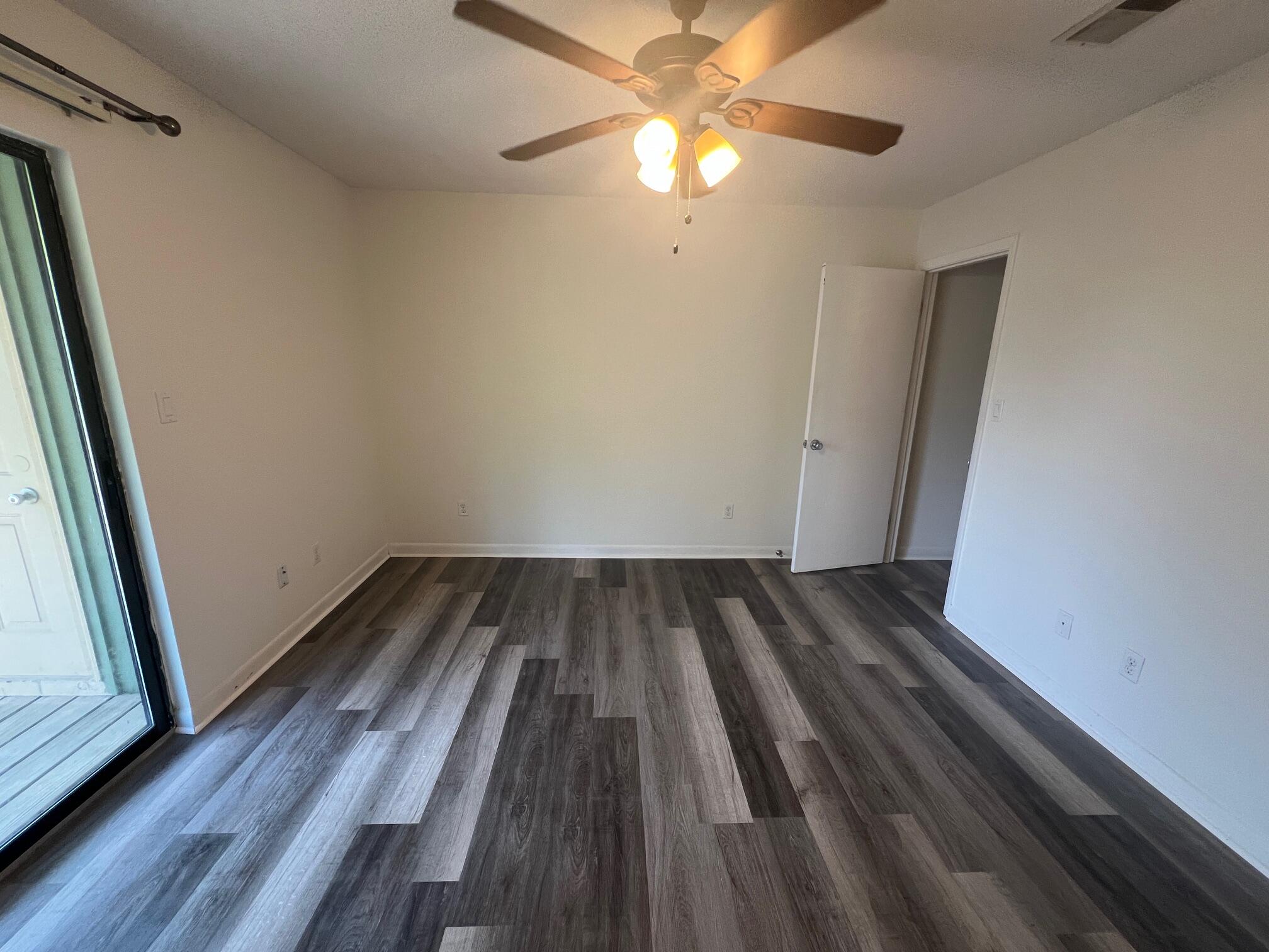 115 Hughes Street Northeast, Unit D4 Fort Walton Beach, FL 32548 - Photo 17 of 29 a view of a room with wooden floor and a ceiling fan
