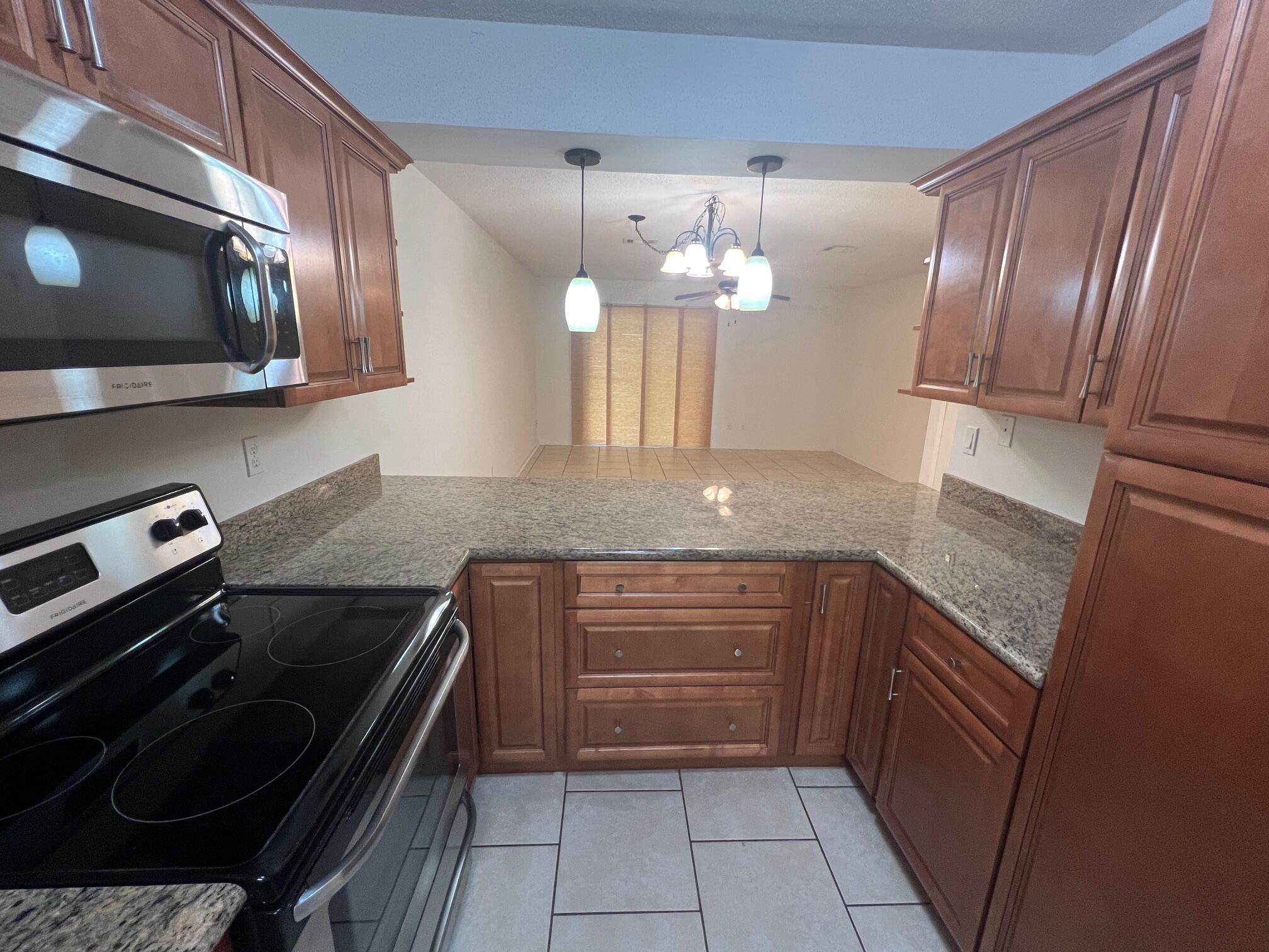 115 Hughes Street Northeast, Unit D4 Fort Walton Beach, FL 32548 - Photo 10 of 29 a kitchen with granite countertop stainless steel appliances and wooden cabinets