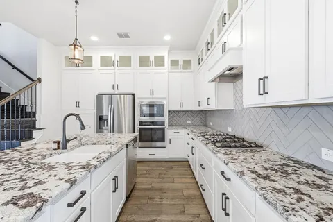 a kitchen with kitchen island granite countertop a sink stove and cabinets