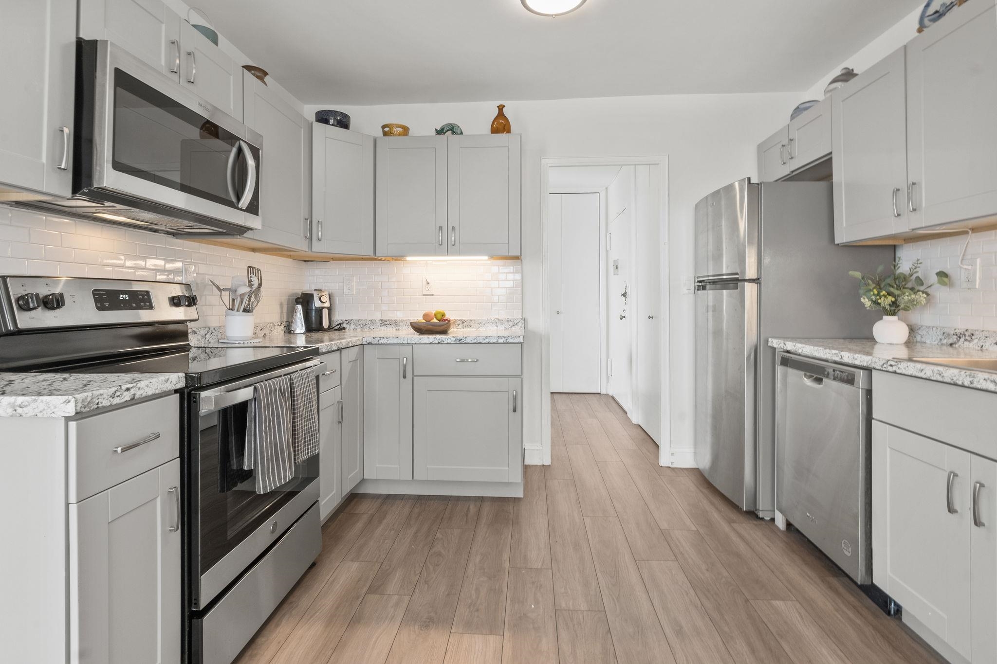 380 Mountain Road, Unit 813 Union City, NJ 07087 - Photo 15 of 40 a kitchen with stainless steel appliances a stove microwave and cabinets