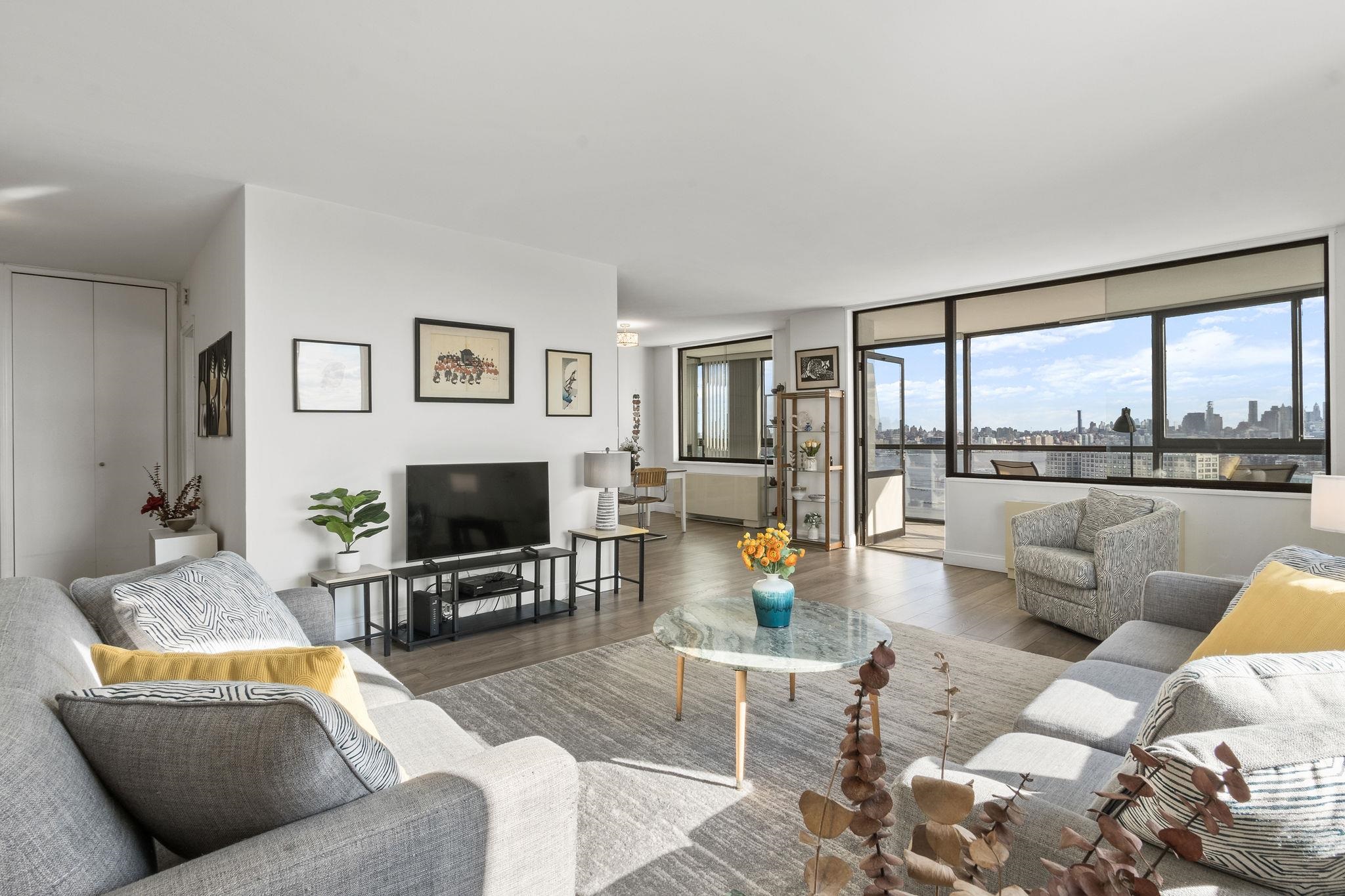 380 Mountain Road, Unit 813 Union City, NJ 07087 - Photo 4 of 40 a living room with furniture and a flat screen tv