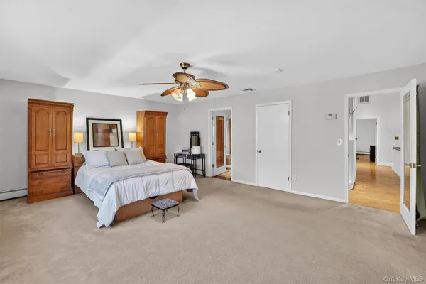 a spacious bedroom with a bed and ceiling fan