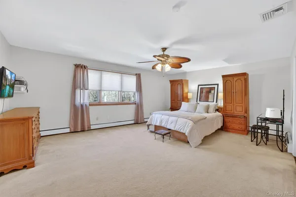 a spacious bedroom with a bed and wooden floor