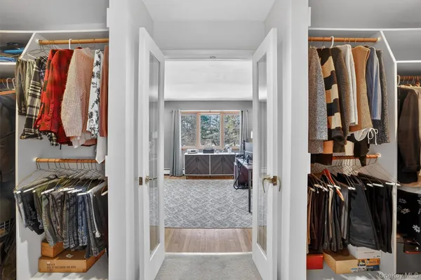 a view of walk in closet with clothes and shoes