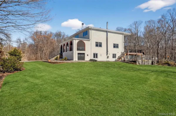 a view of a house with a big yard and large trees