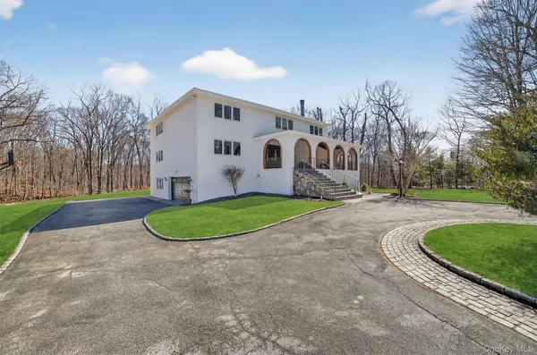 a view of a white house with a yard and large tree