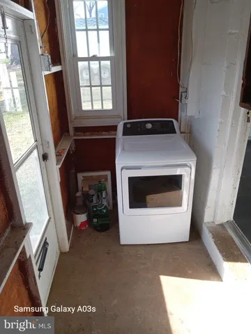 a view of empty room with window and wooden floor