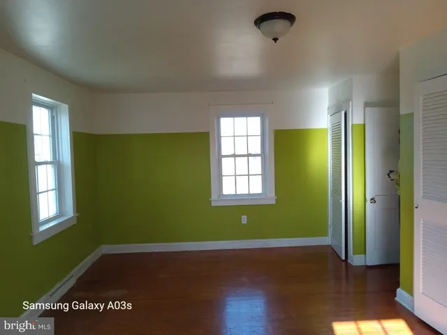 an empty room with a window and wooden floor