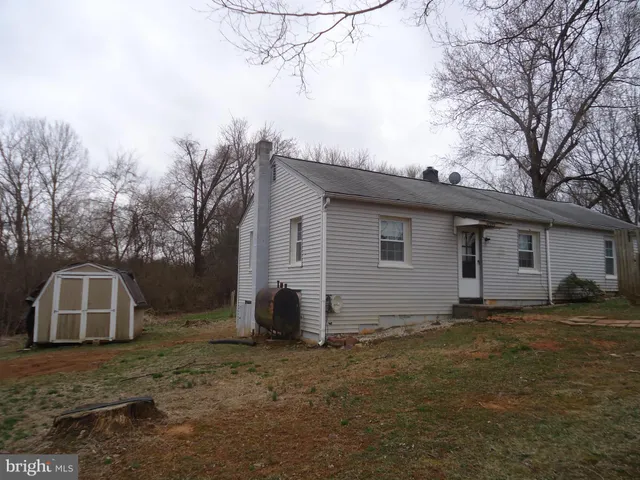 a view of a house with backyard and trees