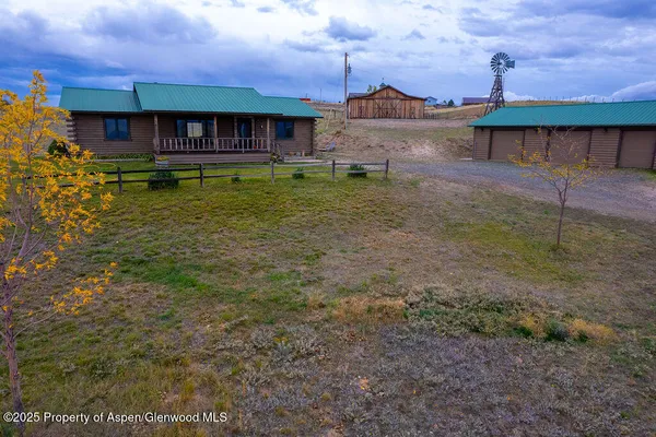 a view of a big house with a big yard and large trees