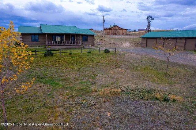a view of a big house with a big yard and large trees