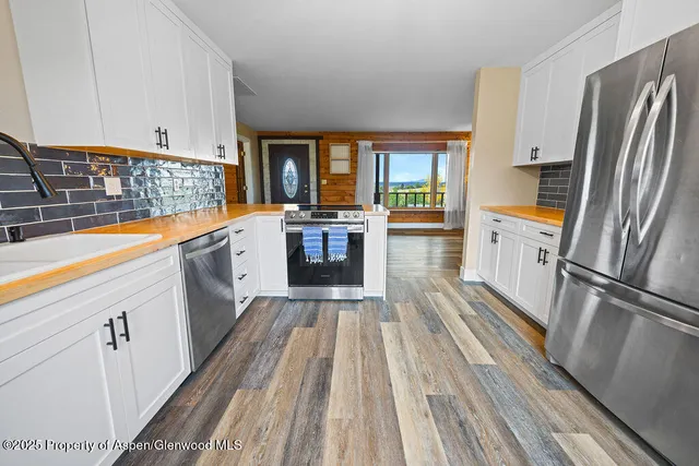 a view of a room with wooden floor and windows