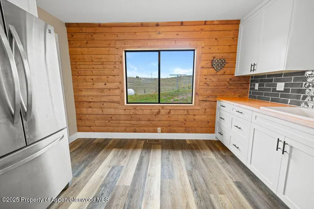a view of a kitchen with wooden floor and a window